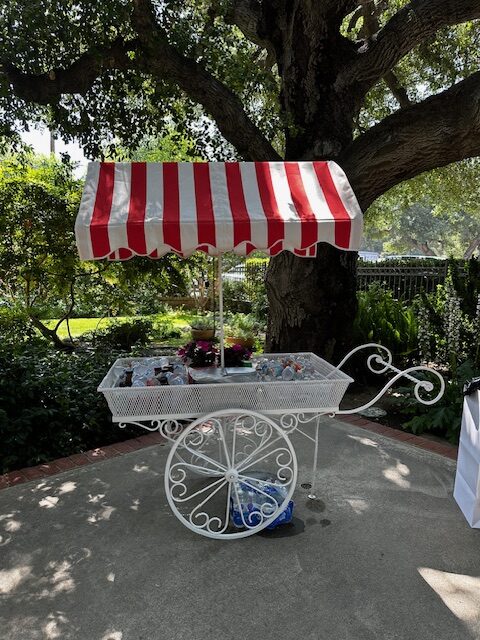 A quaint cart with a red-striped cover held ice-chilled water bottles