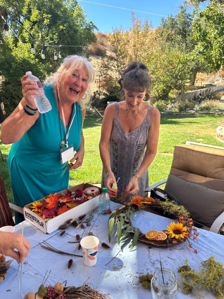 Susan looks forward to a cool drink on a hot day, while Christine finishes her wreath